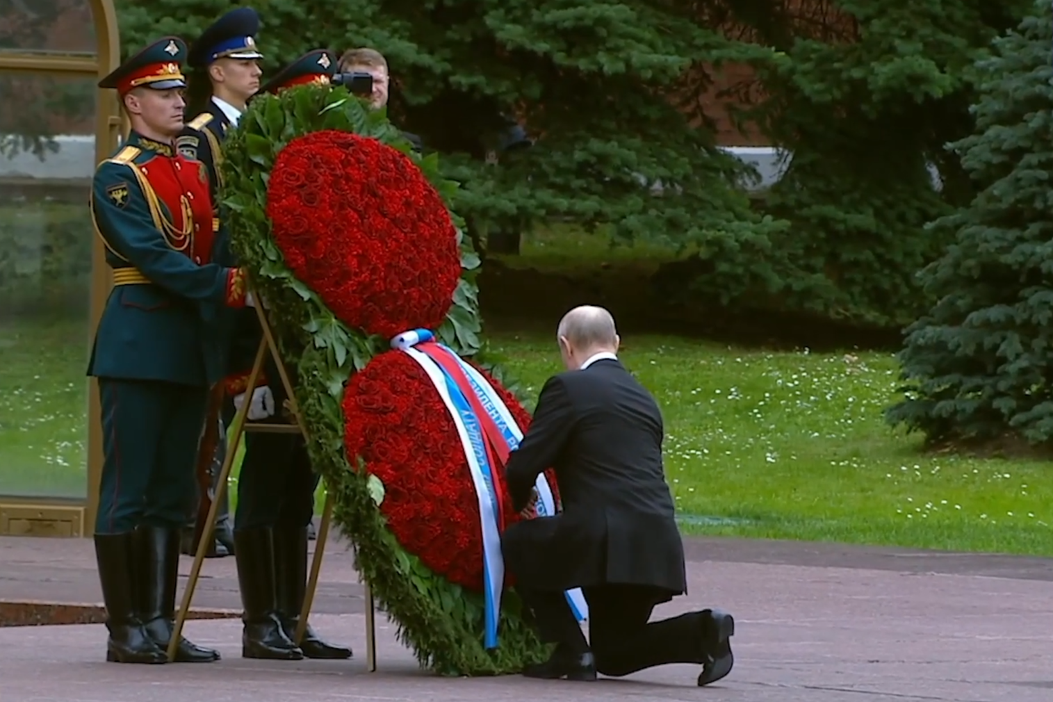 Владимир Путин поправляет ленты на венке.