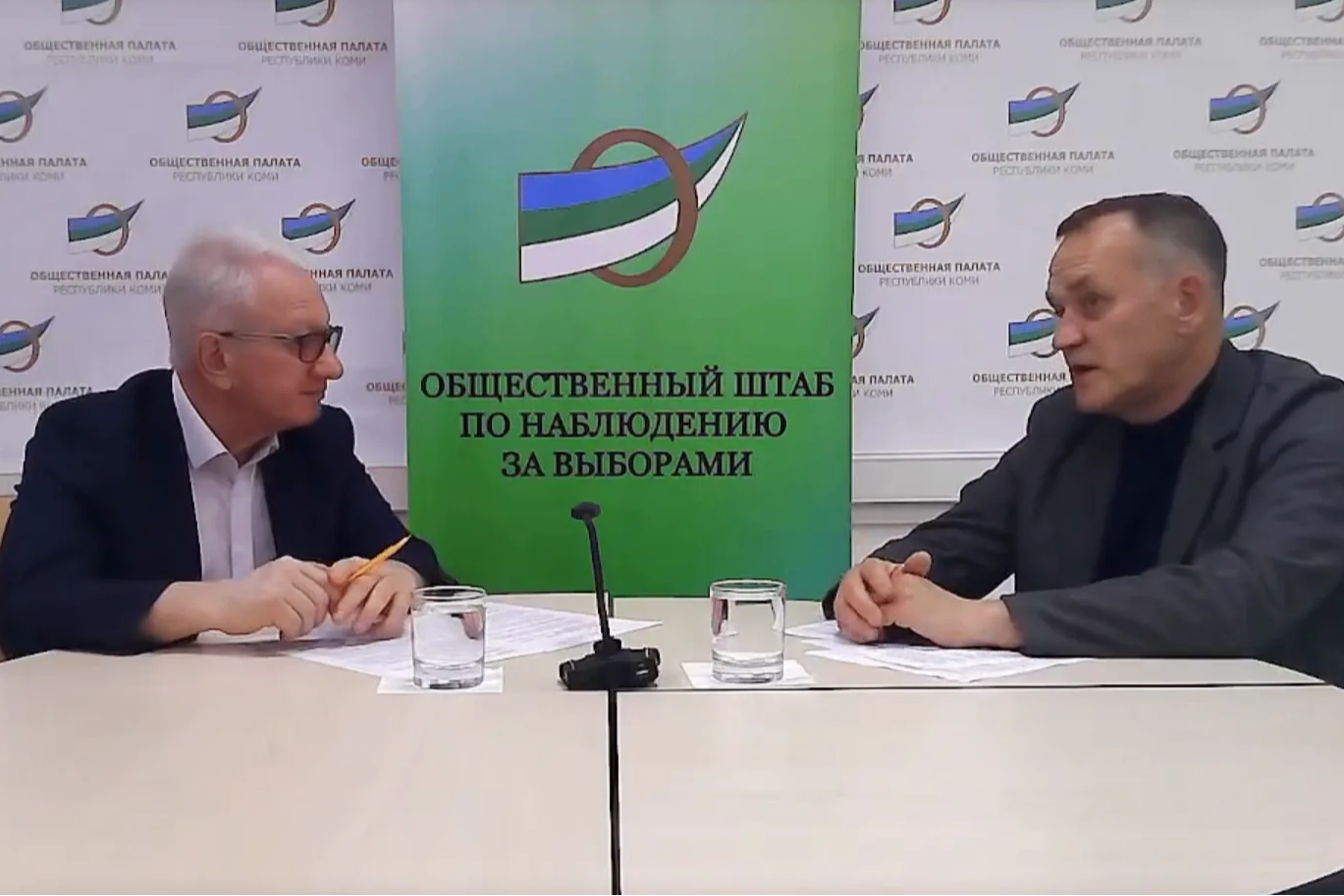 мужчины сидят за столом.